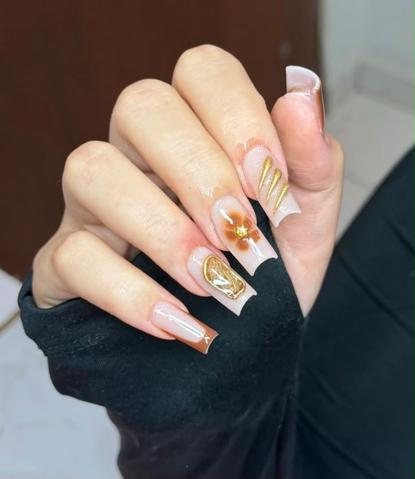 Unhas alongadas com decoração dourada